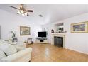 Cozy living room featuring tile floors, a fireplace, and a large television at 36 Trailside Ct, Henderson, NV 89012