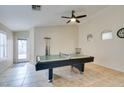 The game room with a ceiling fan, billiards table, and light tile floors, offers entertainment space at 4417 Gracemont Ave, Las Vegas, NV 89139