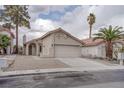 Single story stucco home featuring a tile roof, desert landscaping, and two car garage at 5328 Walton Heath Ave, Las Vegas, NV 89142