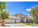 Attractive one-story home with a spacious three-car garage and lush front yard at 5641 Morning Snow Ct, Las Vegas, NV 89141