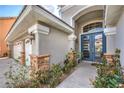 Close-up of front entrance with double doors, stone accents, and a three-car garage at 5641 Morning Snow Ct, Las Vegas, NV 89141