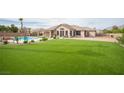 Well-maintained backyard with a large lawn, covered patio, mature landscaping and beautiful pool at 5815 Pristine Falls Ave, Las Vegas, NV 89131