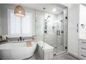 Modern bathroom featuring a standalone tub, glass-enclosed shower, and white cabinetry at 5815 Pristine Falls Ave, Las Vegas, NV 89131