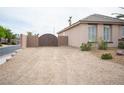 A gravel-covered front yard with a charming brown gate leading to a single-story home at 5815 Pristine Falls Ave, Las Vegas, NV 89131