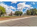 Well-kept home featuring a stone chimney, chain-link fence, and a spacious landscaped yard at 5906 Bunch St, Las Vegas, NV 89122