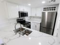 Bright kitchen featuring stainless steel appliances, marble countertops, white cabinetry, and stainless steel sink at 601 Cabrillo Cir # 754, Henderson, NV 89015