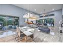 Open-concept living and dining area with modern decor, high ceilings, and access to the outdoors at 6103 Stone Rise St, Las Vegas, NV 89135