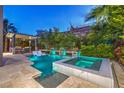 Inviting backyard pool with a hot tub, fire features, and a covered outdoor kitchen at 6103 Stone Rise St, Las Vegas, NV 89135
