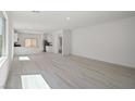 Bright open-concept living space with modern flooring and an adjacent kitchen at 6755 Violet Cascade Ave, Las Vegas, NV 89156