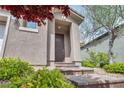 Close up of home's entrance with tiled staircase and mature landscaping at 9370 Burning Sage Ave, Las Vegas, NV 89149
