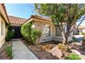 Close up view of the front door and landscaping, complete with mature trees and decorative rock at 1185 Ponce De Leon Ave, Las Vegas, NV 89123