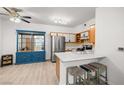 Bright eat-in kitchen features a breakfast bar, stainless steel refrigerator, and blue china cabinet at 5751 Hacienda Ave # 135, Las Vegas, NV 89122