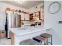 Well-lit kitchen with stainless steel appliances, light countertops, and stylish stools at the breakfast bar at 5751 Hacienda Ave # 135, Las Vegas, NV 89122