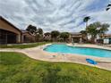 Community pool area features a clean pool, green grass and access to condos in the community at 5751 Hacienda Ave # 135, Las Vegas, NV 89122
