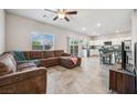 Open concept living room boasts tile floors, a ceiling fan, and modern finishes at 9068 Lennon Ln, Las Vegas, NV 89113
