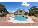 A beautiful swimming pool and hot tub sit in a brick-paved backyard with the house in the background at 10021 Skipper Ct, Las Vegas, NV 89117