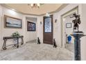 Inviting foyer with tiled floor, decorative statues, and dark wood front door with glass at 10024 Scenic Walk Ave, Las Vegas, NV 89149