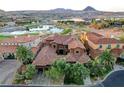 A high-angle bird's eye view of a luxury home with red tile roof and lush landscaping near a serene lake at 15 Rue Du Rivoli Pl, Henderson, NV 89011