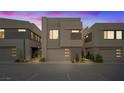 A modern home with sleek design and minimalist landscaping, illuminated by the soft glow of twilight at 16 Heron Harbour Dr, Henderson, NV 89011