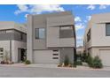 Modern home with a clean design, featuring a gray facade, minimalist landscaping, and an attached garage at 16 Heron Harbour Dr, Henderson, NV 89011