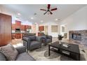 Spacious living room showcases a stone fireplace, ceiling fan, and modern furniture arrangement at 7908 Morning Gallop Ct, Las Vegas, NV 89131