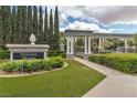 Elegant community entrance with manicured landscaping and decorative pillars under a cloudy sky at 1501 Via Salaria Ct, Henderson, NV 89052
