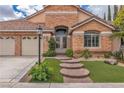 Charming home with a brick facade, well-manicured lawn, and a spacious three-car garage at 1501 Via Salaria Ct, Henderson, NV 89052