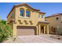 Inviting two-story home showcasing a well-maintained front yard and a two-car garage with a brick-paved driveway at 320 Point Loma Ave, North Las Vegas, NV 89031