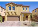 Two-story home showcasing a well-maintained front yard and a two-car garage with a brick-paved driveway at 320 Point Loma Ave, North Las Vegas, NV 89031