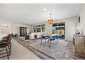 Bright living room boasts wood floors, contemporary furniture, and a sliding glass door to the backyard at 605 Cadence Vista Dr, Henderson, NV 89011