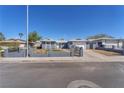 Street view of single-story home featuring desert landscaping, secure fencing, and a two-car garage at 6770 Laronda Ln, Las Vegas, NV 89156