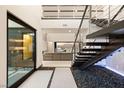 Grand foyer with open staircase, modern design, and bright natural light, flowing into the living space at 12 Falling Canyon Ct, Henderson, NV 89011