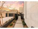 Inviting walkway leads to a modern home with desert landscaping and sleek architectural details at 12 Falling Canyon Ct, Henderson, NV 89011