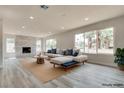 Staged living room showcases a stylish couch, area rug, and views of palm trees outside the large windows at 1400 Cottonwood Pl, Las Vegas, NV 89104