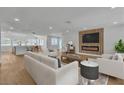 Bright living room featuring modern decor, fireplace, wood floors, and view to kitchen at 2749 Horseshoe Dr, Las Vegas, NV 89120