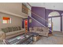 Inviting living room with tile flooring, a staircase, neutral furniture, and stylish decor at 2819 Prickley Pear Dr, Henderson, NV 89074