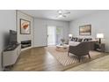 Bright living room with modern fireplace, wood-look flooring, ceiling fan, and sliding glass door at 2975 Bluegrass Ln # 811, Henderson, NV 89074