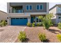 Contemporary two-story home with blue garage door, minimal landscaping, and a brick driveway at 363 Terrill Ave, Las Vegas, NV 89183