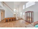 Open-concept living room featuring high ceilings, a wooden staircase, and plenty of natural light at 3735 Morning Canyon St, Las Vegas, NV 89147