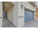Paver driveway leading to a two-car garage, accented by exterior lighting and gray stone at 3903 Ramura Ave, North Las Vegas, NV 89084