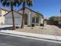 Street view of attractive home with desert landscaping, palm trees, and neutral tones at 5240 Sweet William St, North Las Vegas, NV 89081