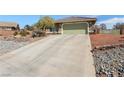 Long cement driveway leads to an attached garage and a house with desert-style landscaping in front at 5481 Lincolnwood Ct, Pahrump, NV 89061