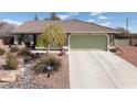 Beautiful home with a green garage door, tile roof, desert landscaping, and a long drive way at 5481 Lincolnwood Ct, Pahrump, NV 89061