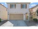 Two-story home featuring an attached garage, arched entryway, and low-maintenance landscaping at 5667 Foxglove Field St, Las Vegas, NV 89130