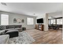 Comfortable living room with a large sectional sofa and wood-look floors, perfect for relaxation at 6013 Aqua Blue Ct, North Las Vegas, NV 89031