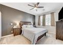 Cozy main bedroom with neutral tones, ceiling fan, and carpeted floors, creating a relaxing retreat at 6013 Aqua Blue Ct, North Las Vegas, NV 89031