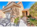 Close-up showcasing the home's entrance, highlighting the manicured landscaping and covered walkway, inviting appeal at 7012 Mercurio Ave, Las Vegas, NV 89131