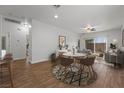 Open concept living and dining area featuring wood-look tile flooring, light neutral walls, and ample natural light at 7849 Lily Trotter St, North Las Vegas, NV 89084