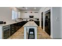 Bright and modern kitchen with black appliances, white cabinets, and a center island at 8073 Villa Pulido St, Las Vegas, NV 89131