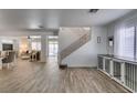 Spacious open-concept living area with wood-look tile flooring and stairway at 8073 Villa Pulido St, Las Vegas, NV 89131